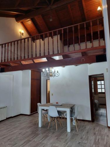 un comedor con mesa y sillas y una escalera en Casa luminosa y Acogedora en Ushuaia