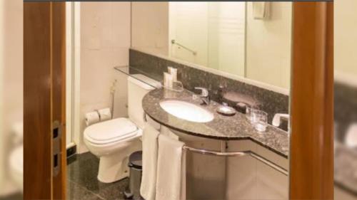 y baño con lavabo, aseo y espejo. en Apart hotel Twin Towers, en Río de Janeiro