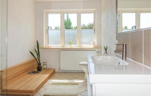 a bathroom with a sink and a toilet and windows at Nice Home In Allinge With 3 Bedrooms And Wifi in Allinge