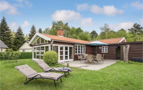 a house with a patio with chairs and a table at Amazing Home In Nysted With Wifi in Nysted