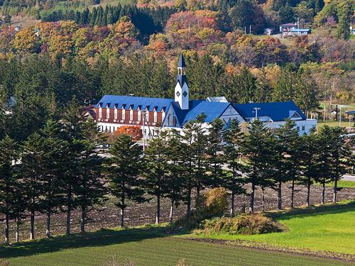 a large building with a church in the middle of a field at Assabu Uzura Onsen Shiki no Yado in Assabu
