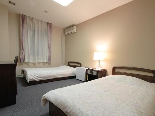 pokój hotelowy z 2 łóżkami i oknem w obiekcie Assabu Uzura Onsen Shiki no Yado 