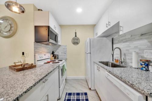 a kitchen with a sink and a refrigerator at Cozy 2 Bedroom Duplex In Charlotte, Jacuzzi, Sleeps 6 plus 2 in Charlotte