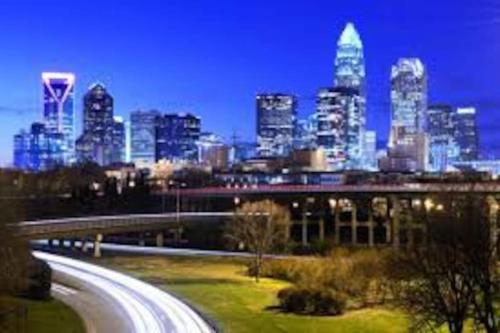 a city skyline at night with a highway in the foreground at Cozy 2 Bedroom Duplex In Charlotte, Jacuzzi, Sleeps 6 plus 2 in Charlotte