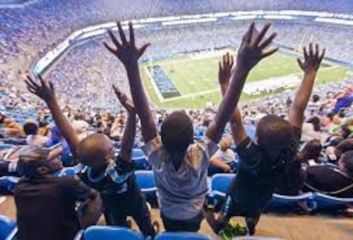 a group of children raising their hands in a stadium at Cozy 2 Bedroom Duplex In Charlotte, Jacuzzi, Sleeps 6 plus 2 in Charlotte