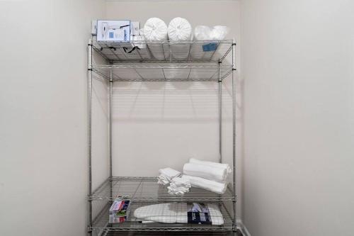 a metal shelf with towels and other items on it at Cozy 2 Bedroom Pineville-Matthews Duplex Sleeps 8 in Charlotte