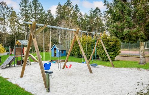 a playground with a swing set in the sand at 2 Bedroom Cozy Home In Nexø in Neksø
