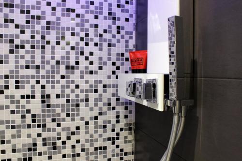 a bathroom with black and white tiles on the wall at Hub Navona in Rome