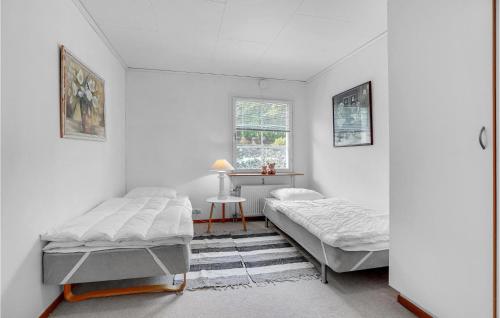 a bedroom with two beds and a desk in it at 3 Bedroom Amazing Home In Frederikshavn in Frederikshavn