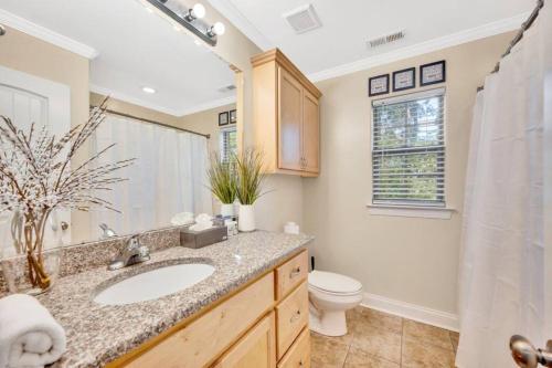 a bathroom with a sink and a toilet and a mirror at Cozy 2B Townhouse King Bed Free Parking TV in BRs in Concord