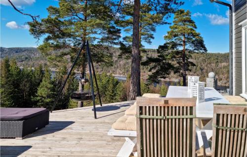 a deck with a hammock and a swing at Lovely Home In Risør With Sauna in Risør