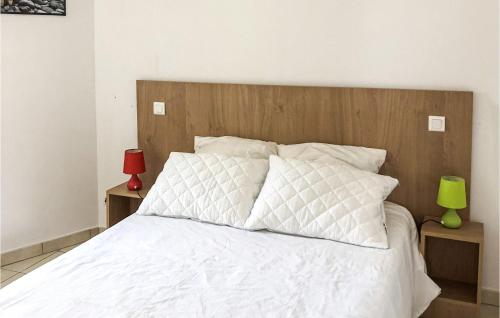 a bedroom with a white bed with a wooden headboard at Le Clos De Rosa in Crillon-le-Brave