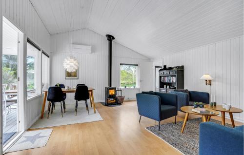 a living room with a table and chairs at 3 Bedroom Pet Friendly Home In Ålbæk in Ålbæk