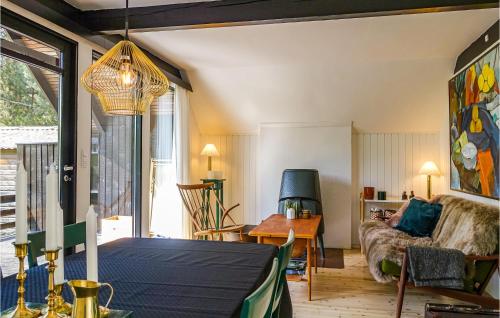 a living room with a table and a couch at Awesome Home In Aakirkeby With Wifi in Vester Sømarken