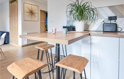 a kitchen with a wooden table and two stools at Cozy Home In Angerville-L'orcher in Angerville-lʼOrcher