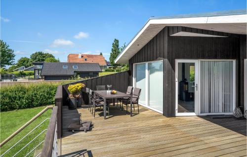 una terraza de madera con mesa y sillas en Stunning Home In Hejls With Kitchen, en Hejls