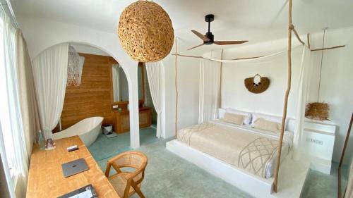 a bedroom with a bed and a table and a ceiling at Guru Canggu in Canggu