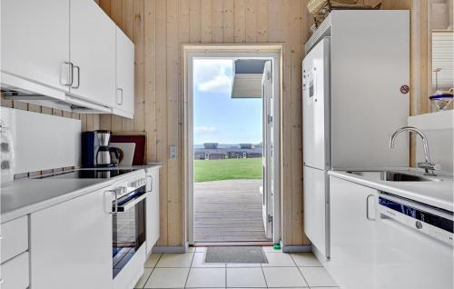 a kitchen with white appliances and an open door at Stunning Home In Faaborg With Wifi in Åstrup