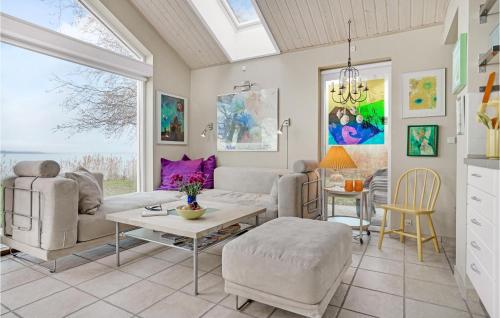 a living room with a couch and a table at Gorgeous Home In Helsinge in Helsinge