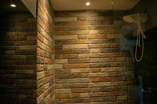 a brick wall in a bathroom with a shower at Black Snapper House in Golfito