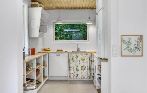 a kitchen with white cabinets and a window at Lovely Home In Fårevejle With Kitchen in Fårevejle