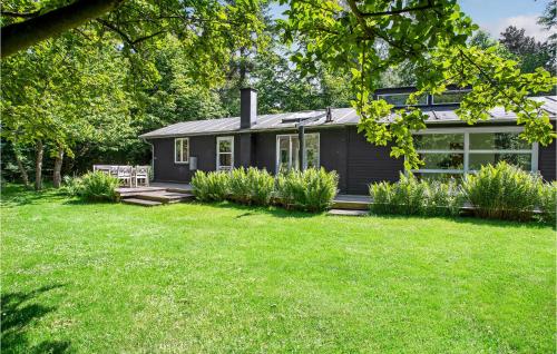 a small black house with a grass yard at Lovely Home In Fårevejle With Kitchen in Fårevejle