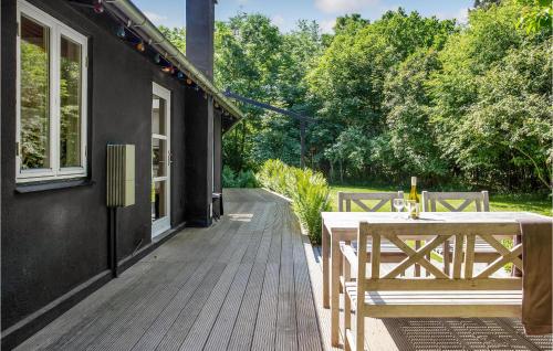 a wooden deck with a table and chairs on a house at Lovely Home In Fårevejle With Kitchen in Fårevejle