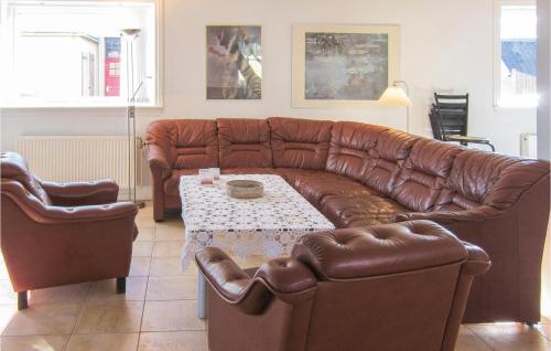 a living room with a brown leather couch and a table at 5 Bedroom Cozy Home In Hasle in Hasle