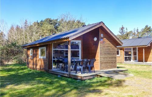 a small cabin with a table and chairs in a yard at Pet Friendly Home In Nexø With Kitchen in Neksø