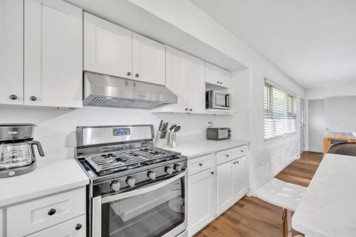 a kitchen with white cabinets and a stove top oven at Cozy 4bedroom Bungalow in Davidson Sleeps 10 in Davidson
