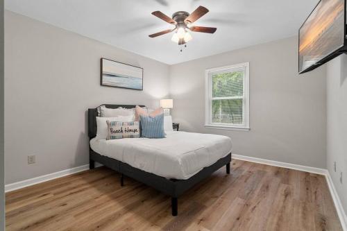 a bedroom with a bed and a ceiling fan at Cozy Lake Home - Jacuzzi King Bed Marina Access in Mooresville