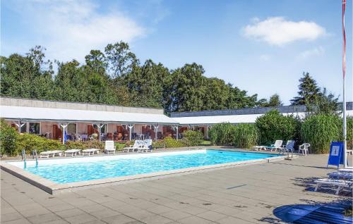 ein Swimmingpool mit Stühlen und einem Gebäude in der Unterkunft Amazing Apartment In Nexø With Sauna in Neksø