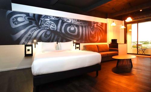 a bedroom with a large white bed and a couch at Boutique Hôtel Kon Tiki Tahiti in Papeete