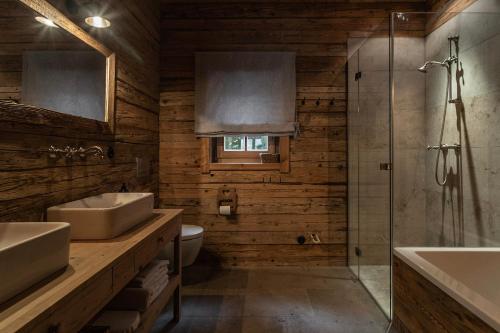 a bathroom with two sinks and a shower at Luxury old wood mountain chalet in a sunny secluded location with gym, sauna & whirlpool in Scheffau am Wilden Kaiser