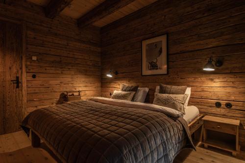 a bedroom with a bed in a log cabin at Luxury old wood mountain chalet in a sunny secluded location with gym, sauna & whirlpool in Scheffau am Wilden Kaiser