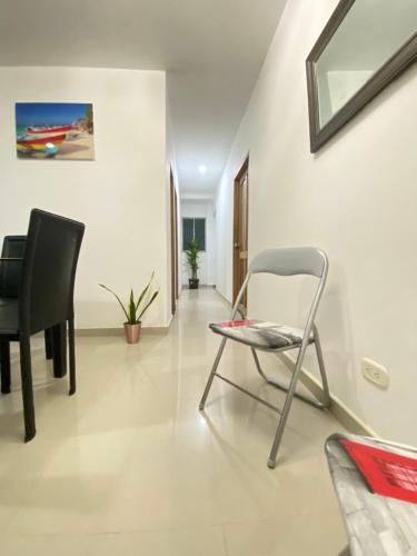 a living room with a chair and a mirror at Apartamento la Isla 1-Coveñas in Coveñas