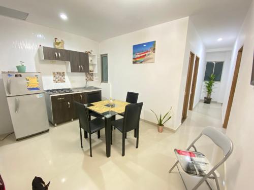 a kitchen with a table and chairs and a refrigerator at Apartamento la Isla 1-Coveñas in Coveñas