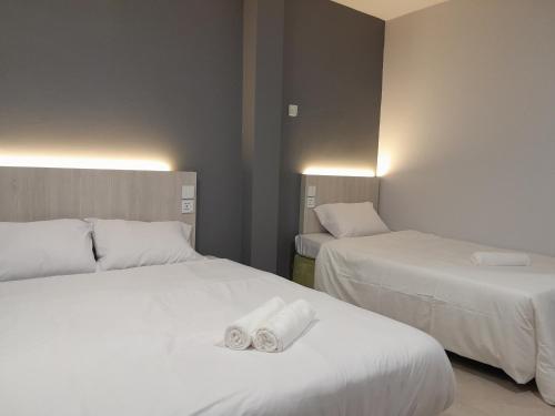 two beds in a hotel room with towels on them at The Great Hotel in Ipoh