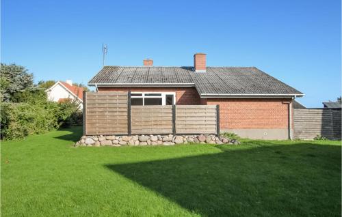 a house with a fence and a grass yard at 3 Bedroom Beautiful Home In Samsø in Ballen