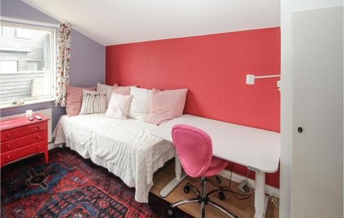a bedroom with a red wall and a bed with a desk at 3 Bedroom Beautiful Home In Samsø in Ballen