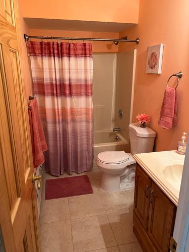 a bathroom with a toilet and a shower curtain at Shore house on Pelican Island! in Seaside Heights
