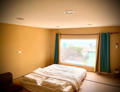 a bed in a room with a window at 自然海naturalhigh in Dahan