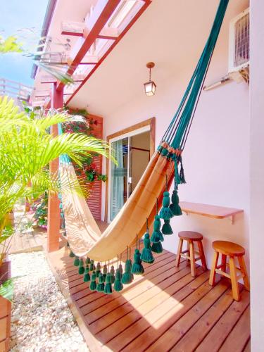 a hammock on the porch of a house at Pousada Origin in Guarda do Embaú
