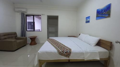 a bedroom with a bed and a chair in it at Gardenia Apartment-03 in Nadi