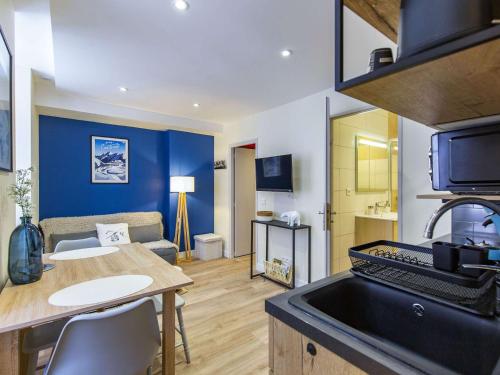 Il comprend une cuisine et un salon avec une table et une cuisinière. dans l'établissement Appartement T2 central à Cauterets, 2-4 pers, skis à 600m, entièrement équipé - FR-1-401-252, à Cauterets