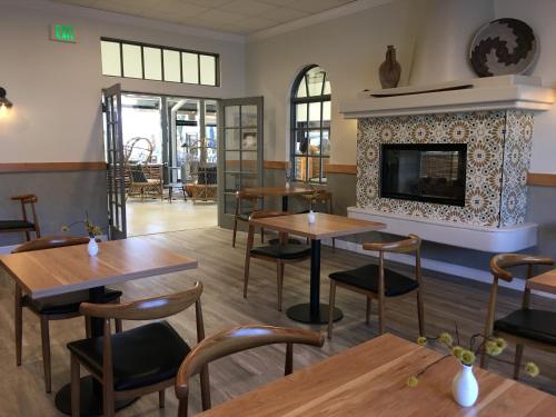 a restaurant with wooden tables and a fireplace at Azure Palm Hot Springs in Desert Hot Springs