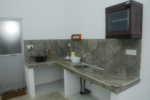 a kitchen counter with a sink and a cabinet at Star Canal Cottage in Negombo