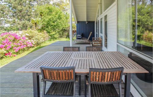 a wooden table and chairs on the porch of a house at Lovely Home In Samsø With Wifi in Onsbjerg