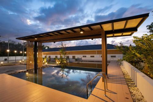 una piscina all'aperto con pergolato accanto a un edificio di Villa Sunrise Garden B190 a Ban Muang Mai