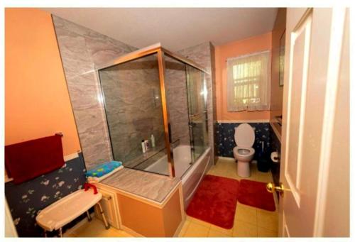 y baño pequeño con ducha y aseo. en 3 Bedrooms 4 Queen Beds Upstairs - Bed & Breakfast - 8 people welcome, en Abbotsford